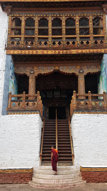 9 listopada 2017 mnich idący w górę do bhutanu tradycyjnego budynku punakha dzong, bhutan - bhutan paro monk town zdjęcia i obrazy z banku zdjęć