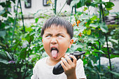 Boy harvesting egg plant with funny face
