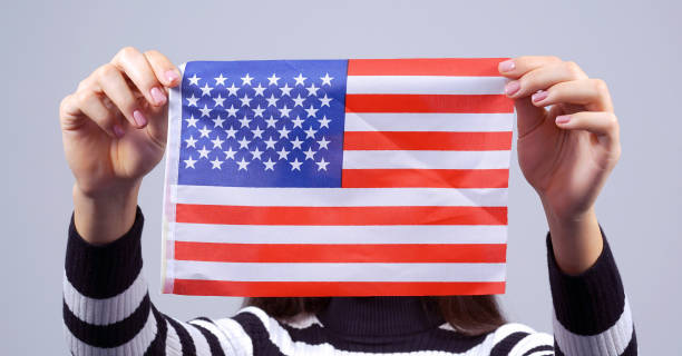istock woman holds usa flag closing face 1219492259