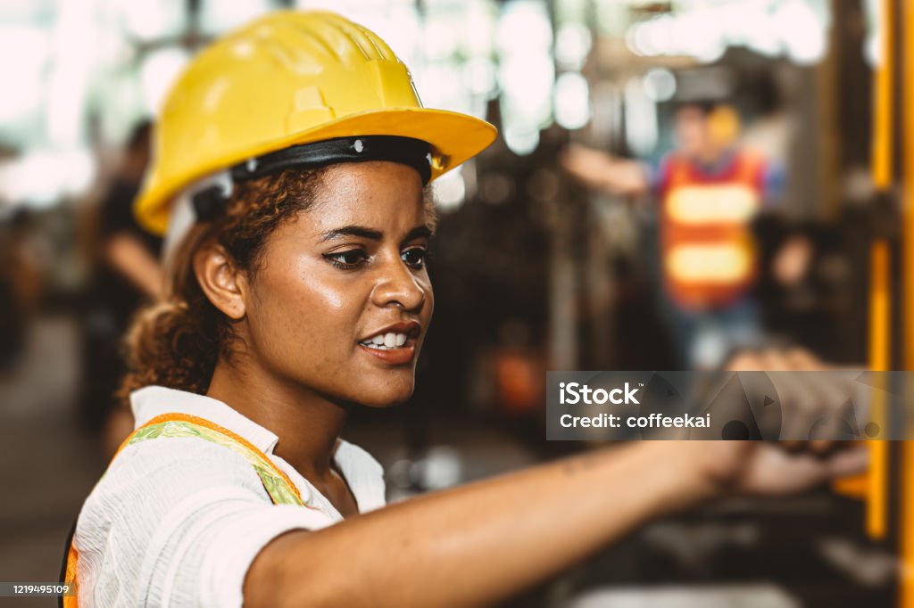 美國黑人婦女青少年工人在工業工廠用重型鋼機工作。 - 免版稅非洲人圖庫照片