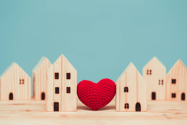 cuore d'amore tra due modelli di legno di casa per stare a casa per un sano concetto di comunità insieme. - vicino di casa foto e immagini stock