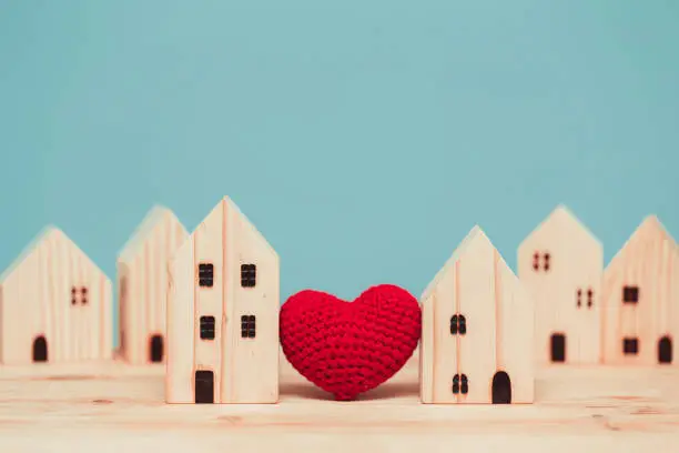 Love heart between two house wood model for stay at home for healthy community together concept.