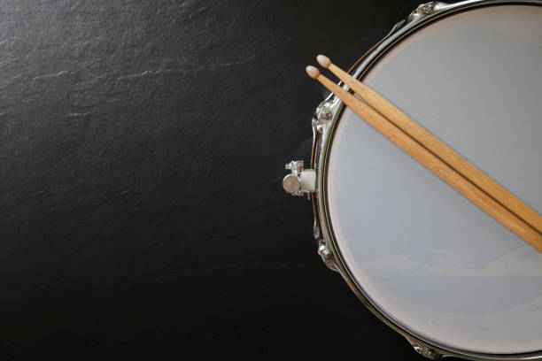 istock Drum stick and drum on black table background, top view, music concept 1219498061