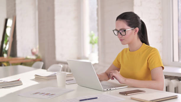 istock Busy Woman Working on Laptop in Modern Office 1219498820
