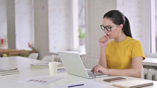 istock Sick Young Female Designer Coughing in Modern Office 1219498836