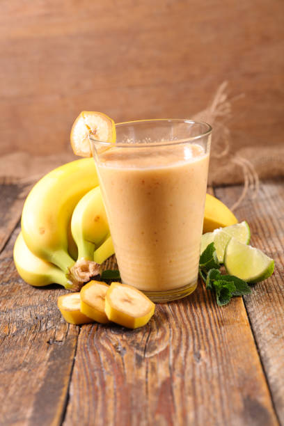 istock banana smoothie- fruit juice on wood background 1219501035