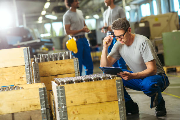 istock Senior manual worker looking at document and examining metal tube 1219502472
