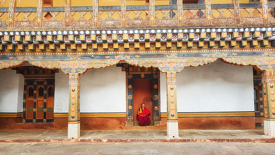 9th November 2017 A Bhutanese monk sitting at the door looking at camera at bhutanese traditional building Punakha Dzong,, Bhutan
