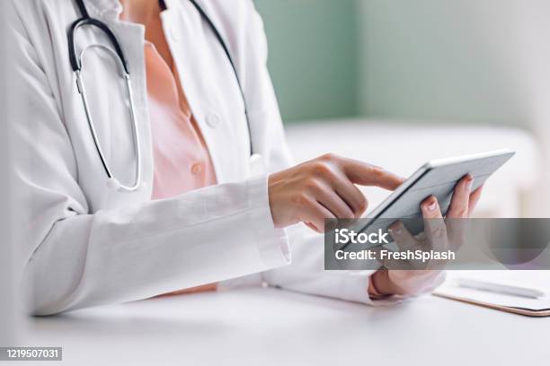 Hands Of A Medical Doctor Using A Digital Tablet At The Office Stock Photo - Download Image Now