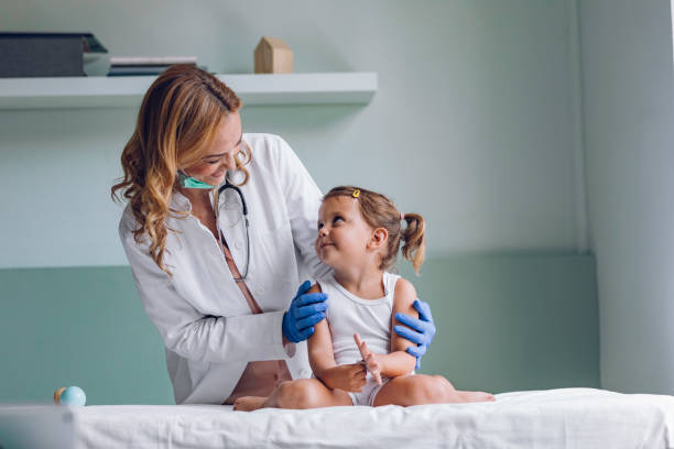 Happy Doctor and a Cute Little Patient during a Medical Checkup Smiling pediatrician examining a cute little girl at her office. todler care stock pictures, royalty-free photos & images