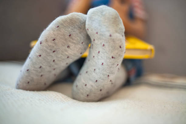 istock Little boy reading a book on the sofa at home 1219508089