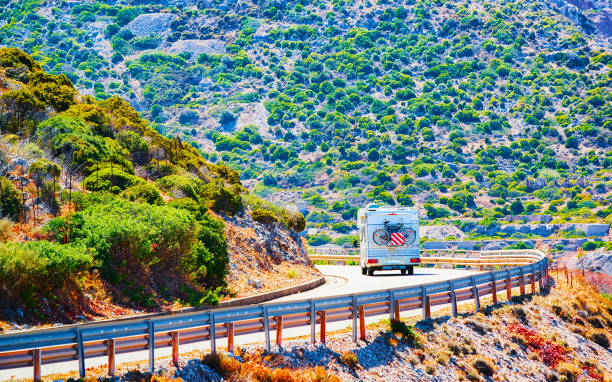 Caravan on road at Buggerru in Carbonia Iglesias Sardinia Vacation trip with Caravan Car with bicycle on road, Italy. Camper and Summer drive on highway. Holiday journey in rv motorhome and sea. Motor home minivan at mountain. Scenery. Buggerru stock pictures, royalty-free photos & images