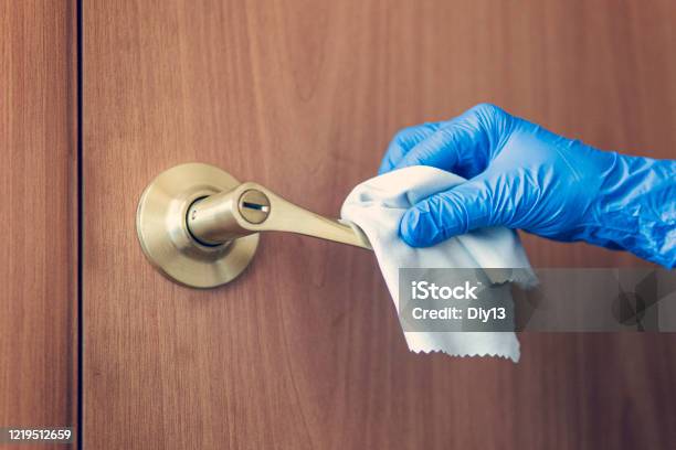 A Womans Hand Wipes The Door Handle With Wet Rag The Maid Is Washing The Doorknob Prevention Of Coronavirus And Bacterial Infections Stock Photo - Download Image Now