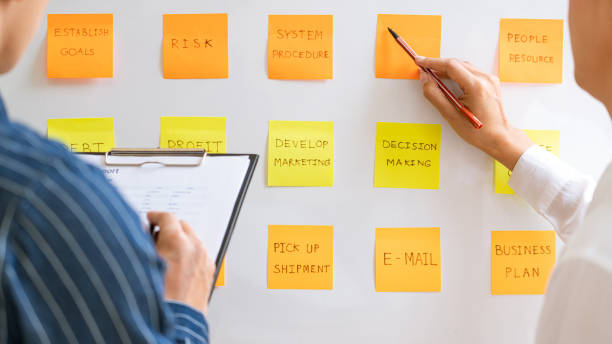istock young business workers posting with sticky notes stickers reminders  creative brainstorming at board the colleague in a modern co-working space 1219516798