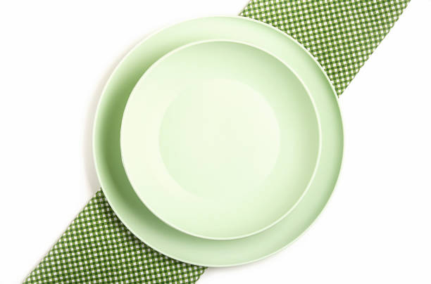 Clean empty plates, on a light background. Napkin on the table. Top view.