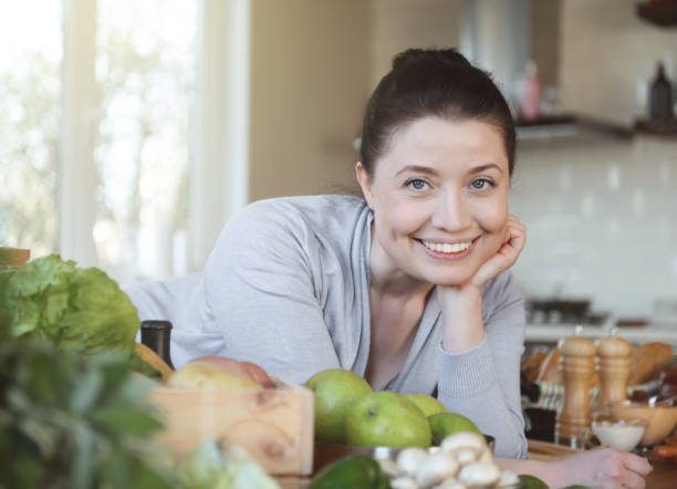 istock beautiful woman in the kitchen 1219519157