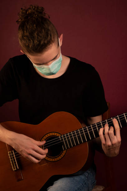 istock Playing guitar in protection mask 1219520271