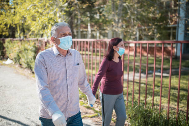 istock Senior couple walking with protective masks and gloves to avoid Covid-19 Coronavirus 1219520522