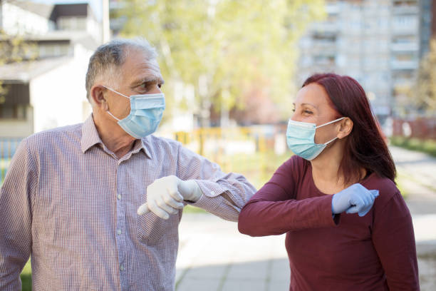 istock Two senior people greeting each other with elbows 1219521817