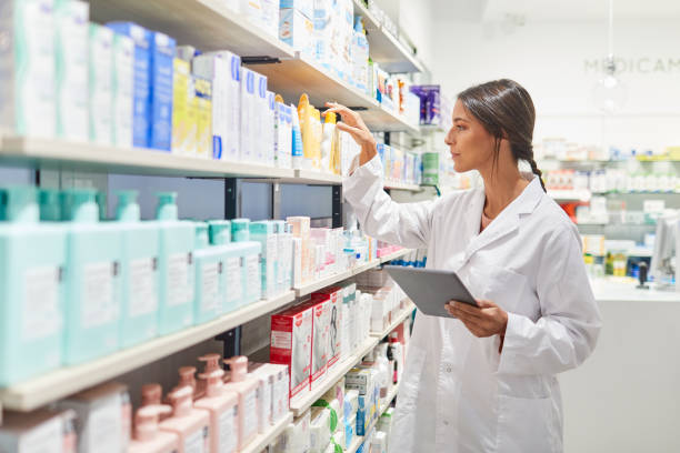 Spanish female pharmacist taking inventory on a digital tablet.