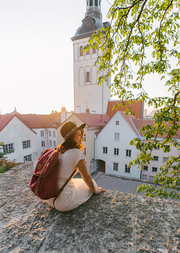 Young Caucasian woman sitting and looking at Tallinn in the morning