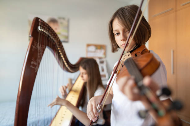 niño y niña tocando música en casa - violin family fotografías e imágenes de stock