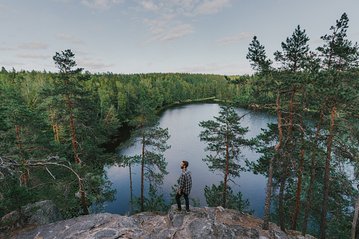 Young Caucasian man walking near the lake in summer