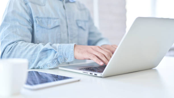 istock Close Up of Young Man using Laptop in Modern Office 1219525668