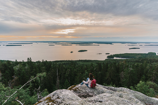 Scenic view of woman looking at  lake in Finland at sunset