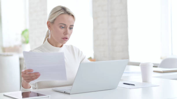 istock Young Businesswoman Working on Documents and Laptop 1219526613