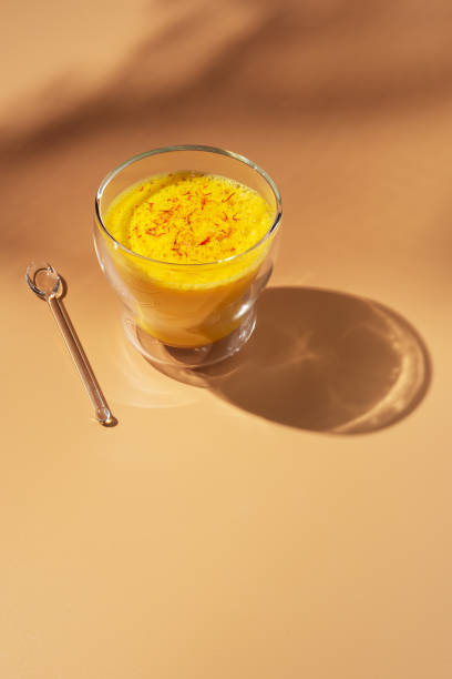 istock Saffron latte in a glass cup on a beige background, golden milk, hard light,space for text. 1219527337