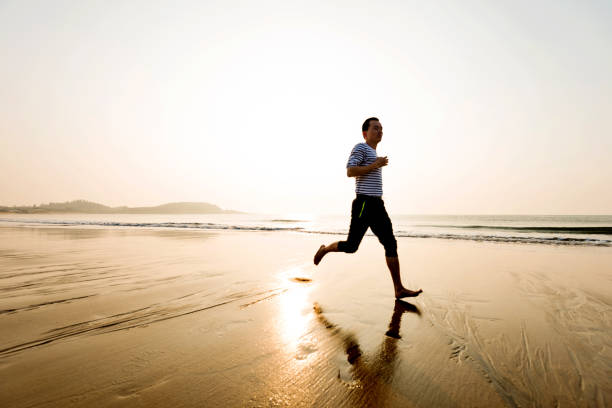 Man running on the beach at sunset.