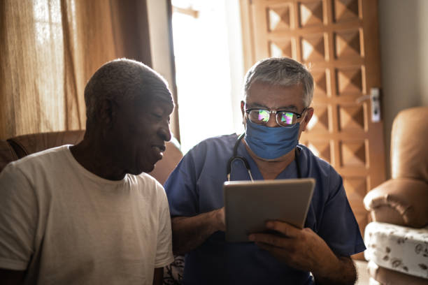 istock Health visitor and a senior man during home visit - using digital tablet 1219530771