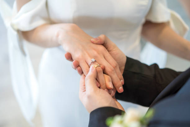 istock Bridegroom putting on the wedding ring for the bride 1219531833
