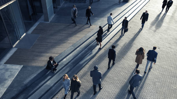 gerentes de oficina y empresarios commute to work on the morning o from office on a sunny day on foot. los peatones están vestidos inteligentemente. gente exitosa caminando en el centro de la ciudad. disparo desde arriba. - smartly fotografías e imágenes de stock