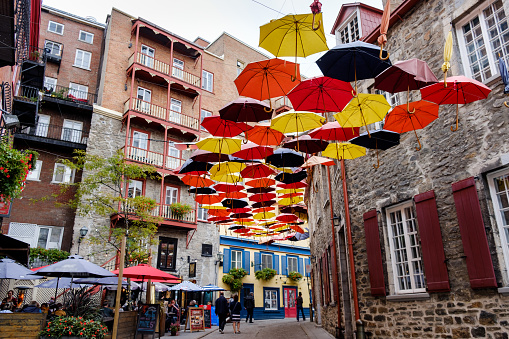 A lovely old town alley with lots of colorful umbrellas hanging from above, September 24th, 2018, Quebec, Canada.