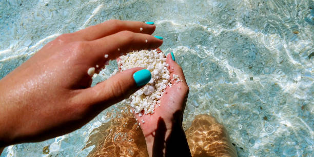 istock Little pebbles in girl`s hands on the beach 1219543225