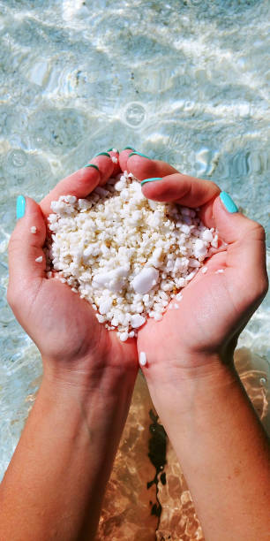 istock Little pebbles in girl`s hands on the beach 1219543381
