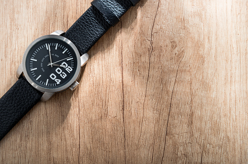Black watch on wooden background