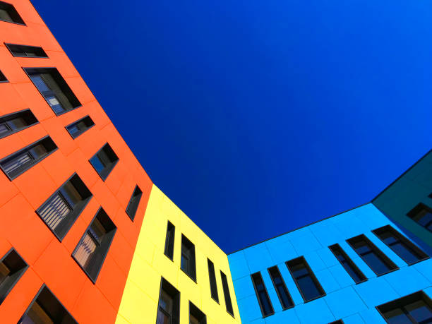 Multi-colored facades of the school with black window frames.