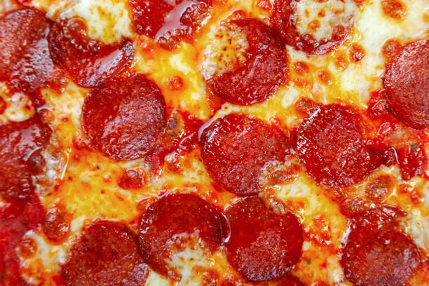 istock Pepperoni pizza with cherry tomatoes, cheese on black background 1219545892