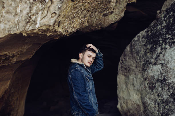 istock Young sad man in a cave in the mountains 1219547712