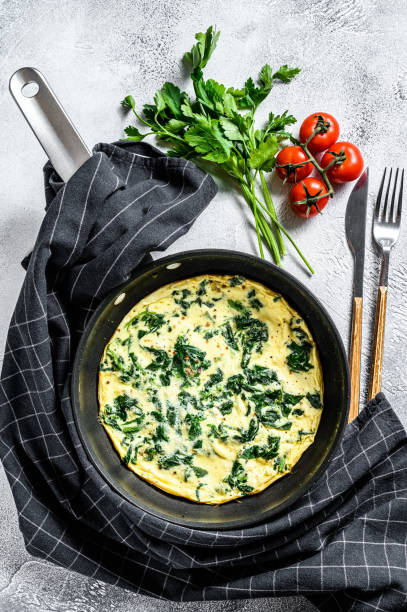 istock Spinach cheese frittata in a pan. Gray background. Top view 1219548810