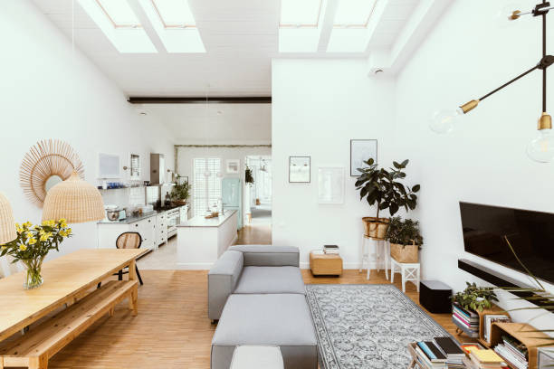 istock Open space living room interior with kitchen, dining room table and grey couch in entertainment center 1219549888