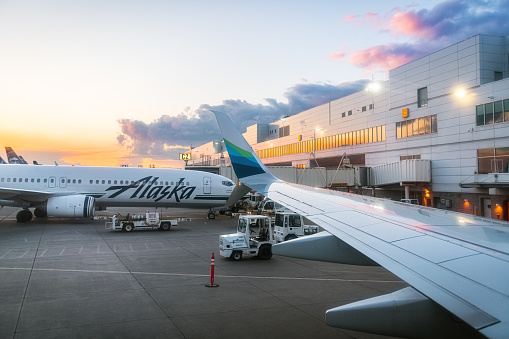 Anchorage, AK, USA - June 11, 2019- The sunsets on Ted Stevens Anchorage International Airport showing an Alaska Airlines plane in Anchorage Alaska.