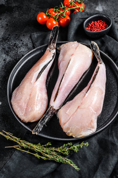 istock Separate fresh monkfish without head and skin. Black background. Top view 1219550038