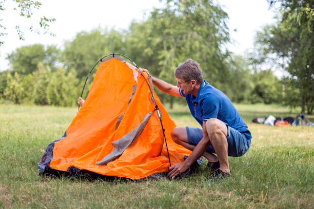 istock Senior man sets up a tent 1219550071