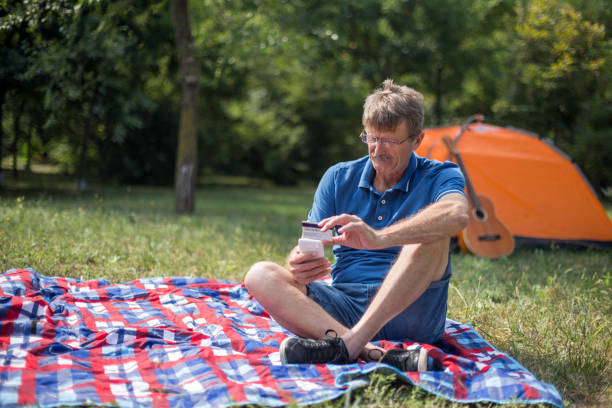 istock Senior man shopping online while having picnic 1219550702