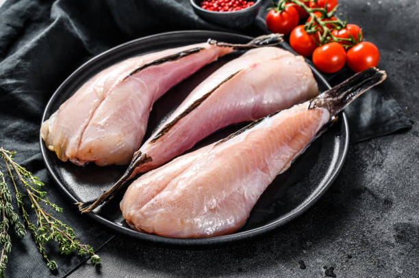 istock Separate fresh monkfish without head and skin. Black background. Top view 1219550797