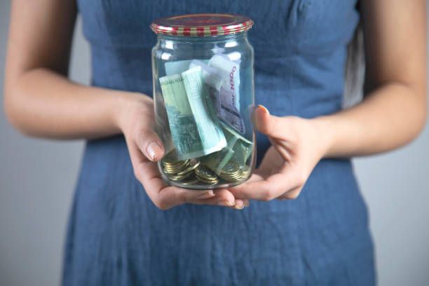 istock woman hand money in jar 1219551168